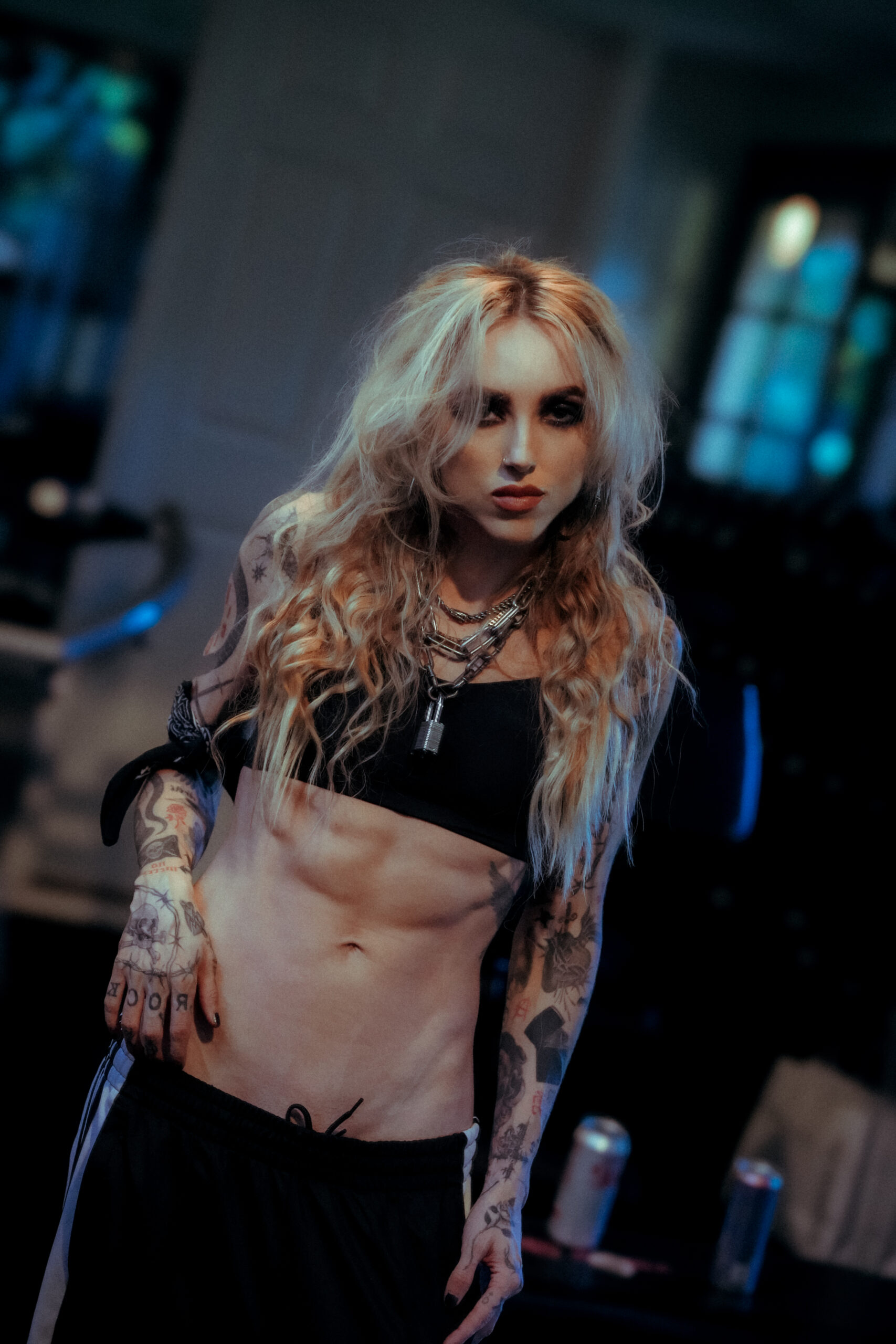 Female fitness coach with visible abs in a gym, representing camera-ready body recomposition coaching.